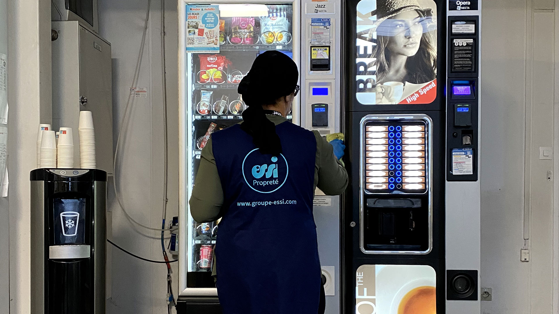 agent qui désinfecte un distributeur automatique
